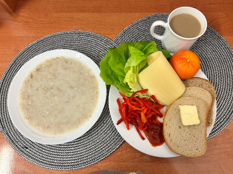 Na zdjęciu znajduje się: Płatki owsiane na mleku, Kawa zbożowa z mlekiem, Chleb mieszany pszenno-żytni, Chleb Graham, Masło extra 82%, Ser żółty, Ketchup, Mandarynka, Papryka konserwowa, Sałata zielona